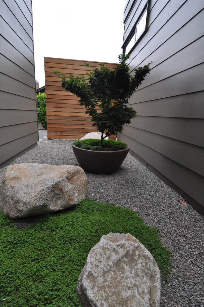Inspiration for a large contemporary partial sun side yard gravel landscaping in Seattle for summer.