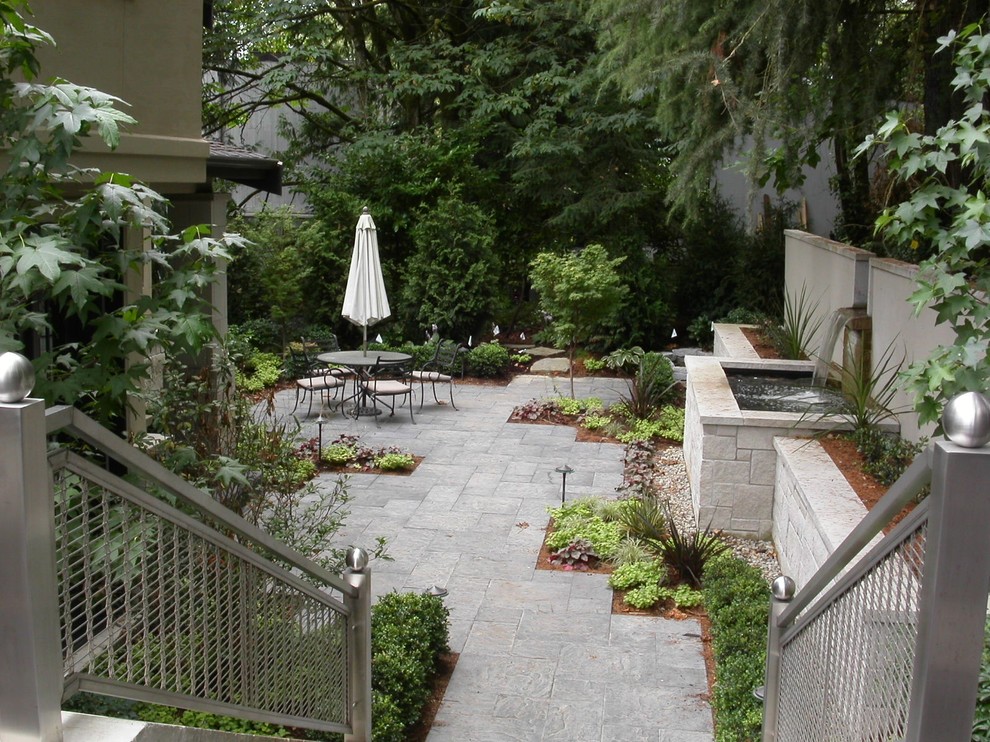 Immagine di un grande giardino design in ombra davanti casa con un ingresso o sentiero e pavimentazioni in pietra naturale
