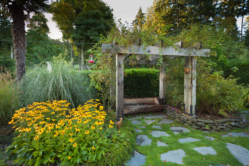 Réalisation d'un jardin arrière tradition avec des pavés en pierre naturelle.