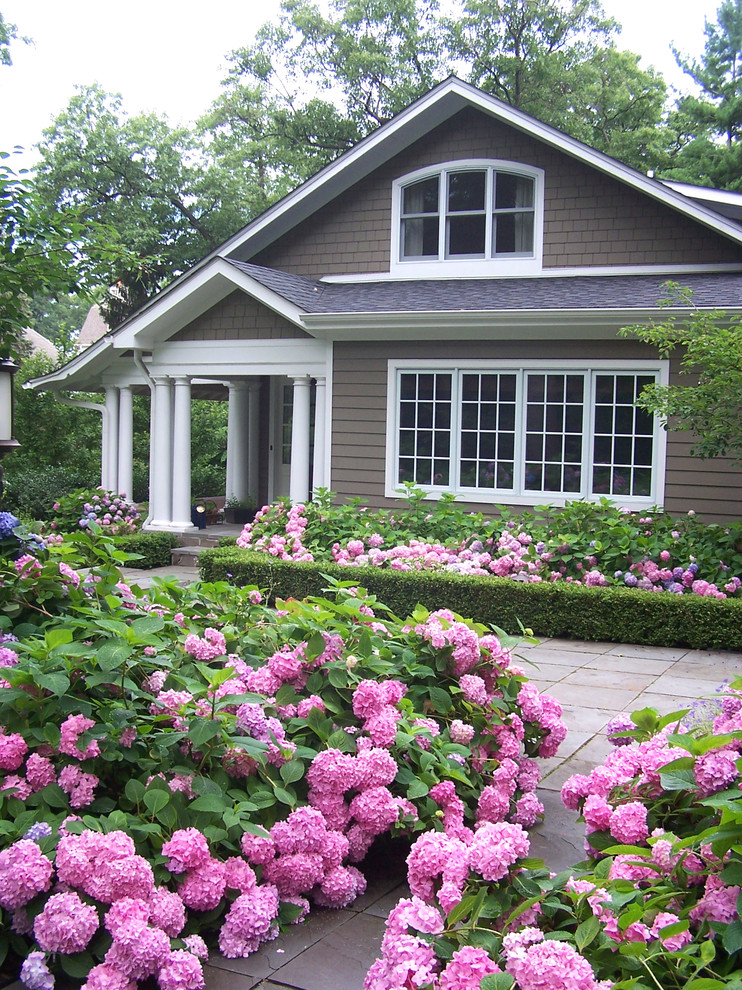 Exemple d'un jardin avant chic avec des pavés en pierre naturelle et un massif de fleurs.