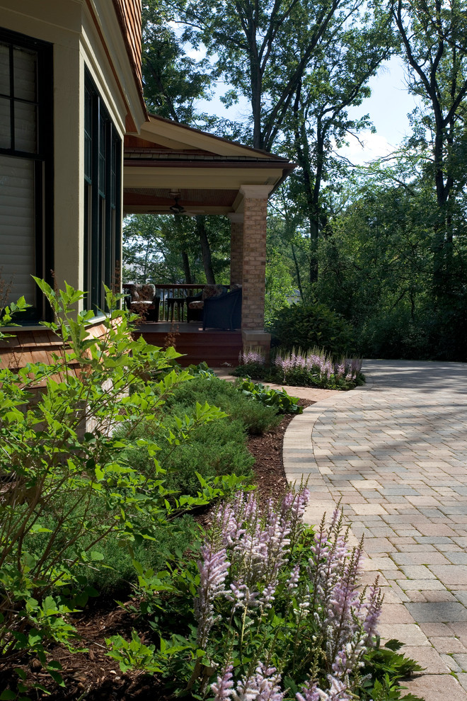 Modelo de acceso privado de estilo americano grande en primavera en patio delantero con exposición reducida al sol y adoquines de hormigón
