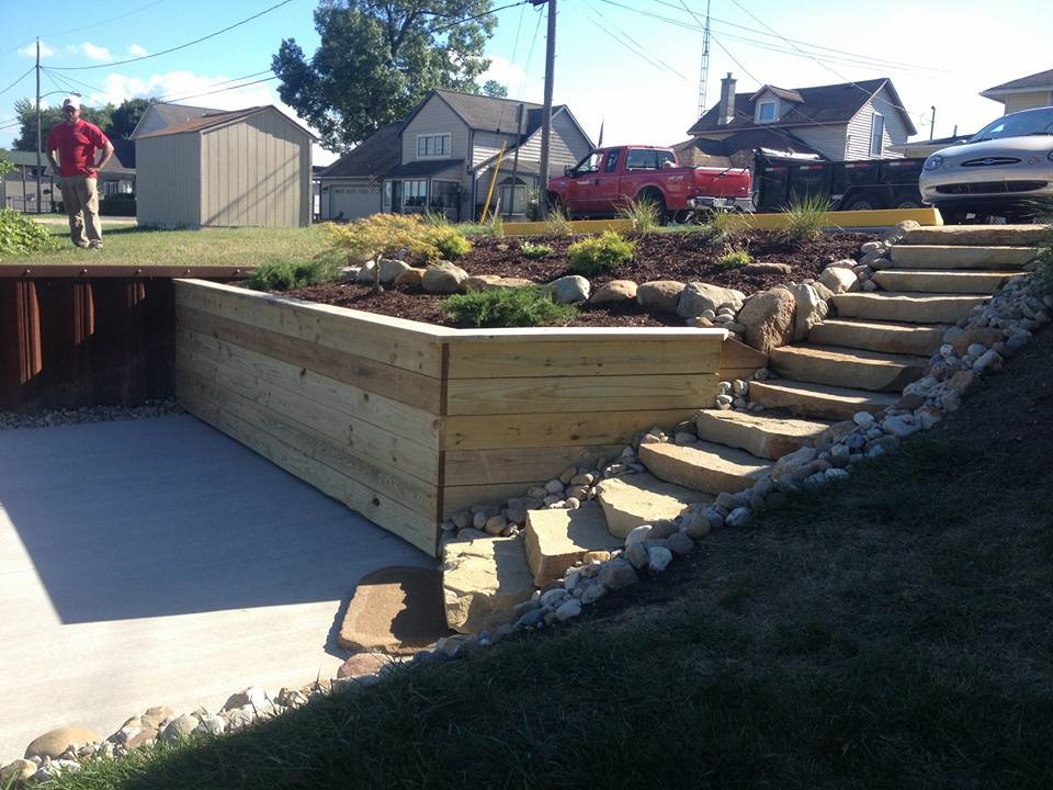 Photo of a medium sized traditional back formal full sun garden for summer in Other with a retaining wall and concrete paving.