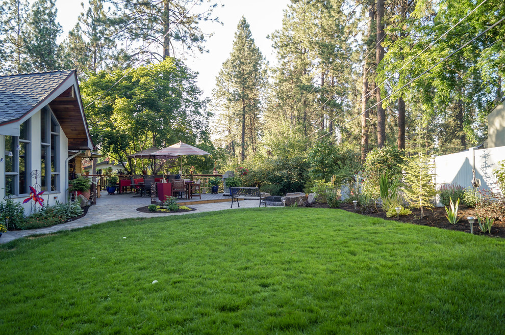 Immagine di un giardino chic esposto a mezz'ombra di medie dimensioni e dietro casa con un focolare e pavimentazioni in cemento