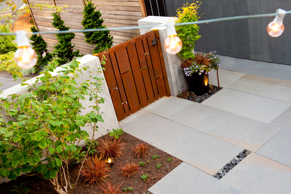 This is an example of a small retro front partial sun garden in Seattle with a garden path and natural stone paving.
