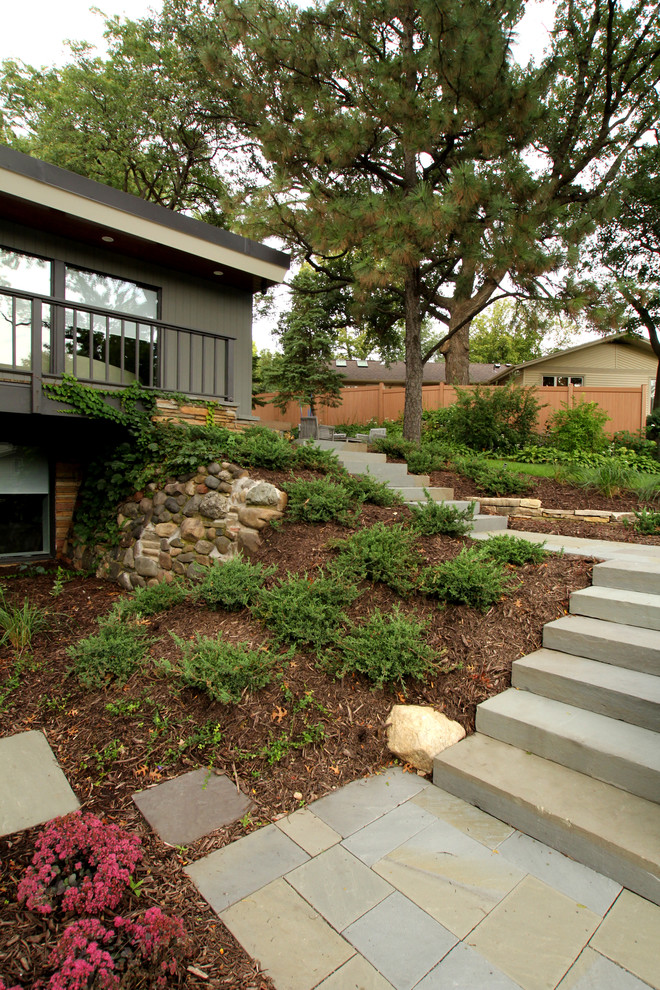 Cette photo montre un aménagement d'entrée ou allée de jardin avant rétro de taille moyenne avec des pavés en béton.
