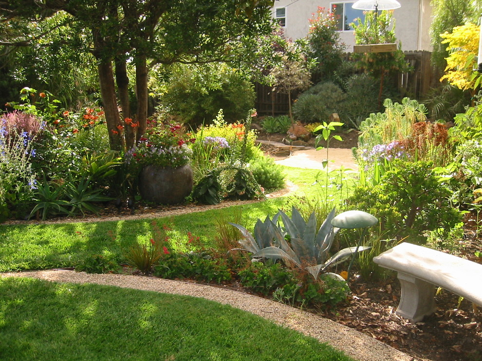 Cette photo montre un grand jardin arrière chic au printemps avec une exposition partiellement ombragée et du gravier.