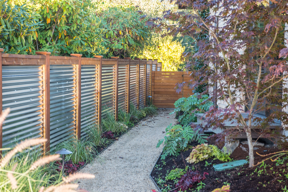 Ejemplo de jardín vintage de tamaño medio en patio con muro de contención y gravilla