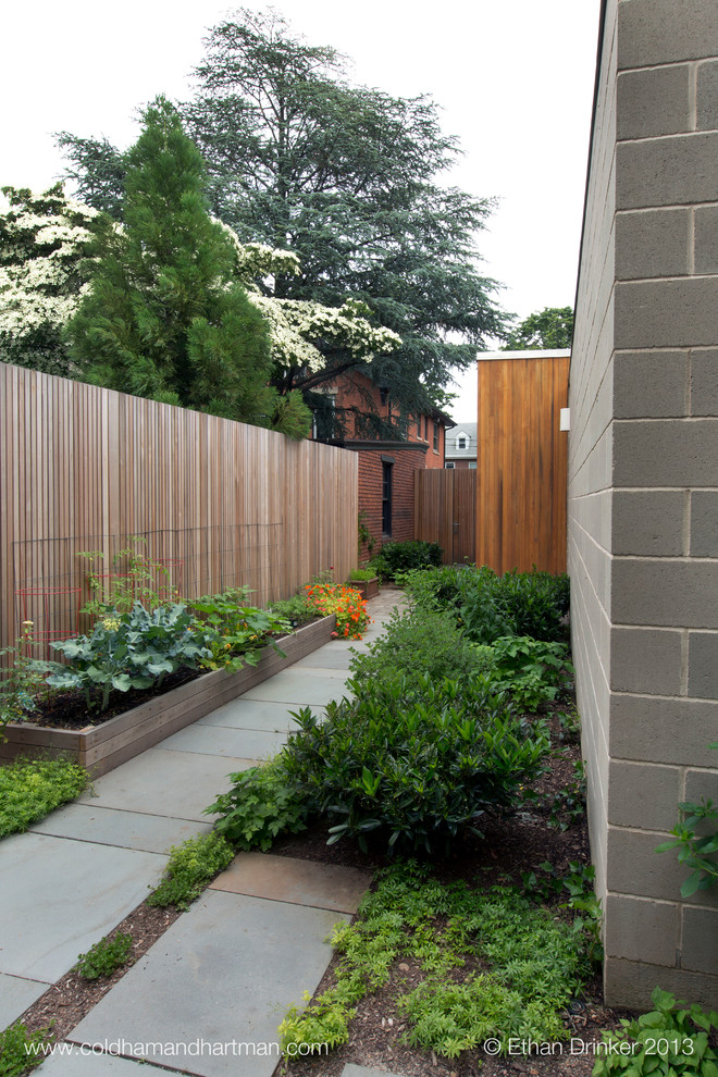 This is an example of a mid-sized mid-century modern partial sun side yard stone formal garden in New York.