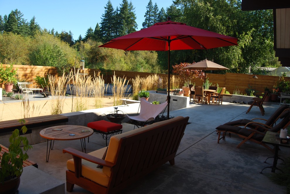 Design ideas for a mid-sized mid-century modern full sun backyard landscaping in Portland.