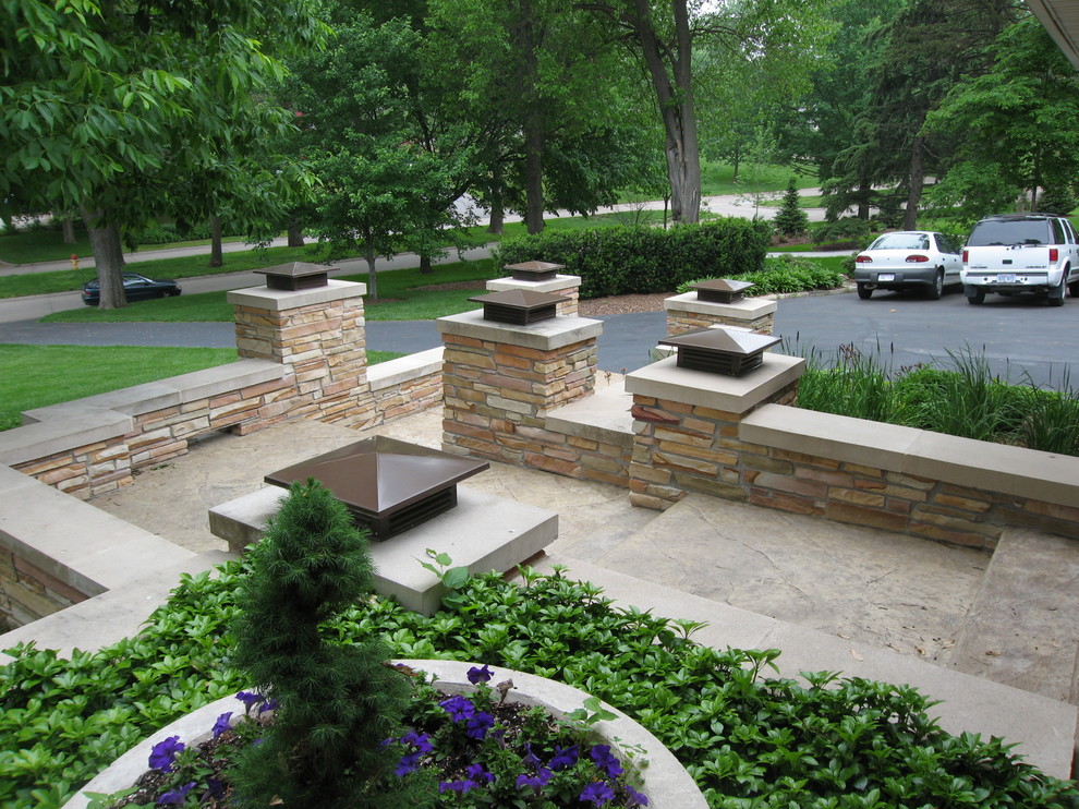 This is an example of a mid-sized mid-century modern partial sun front yard concrete paver landscaping in Omaha.