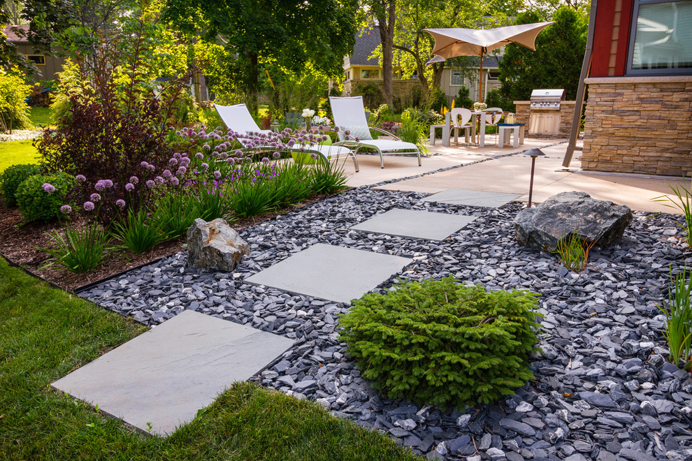 Esempio di un giardino xeriscape moderno esposto in pieno sole di medie dimensioni e dietro casa in estate con ghiaia e un ingresso o sentiero