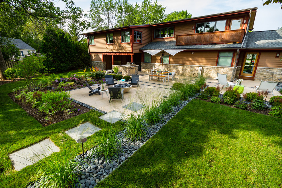 Design ideas for a mid-sized mid-century modern drought-tolerant and full sun backyard landscaping in Milwaukee with a fire pit for summer.