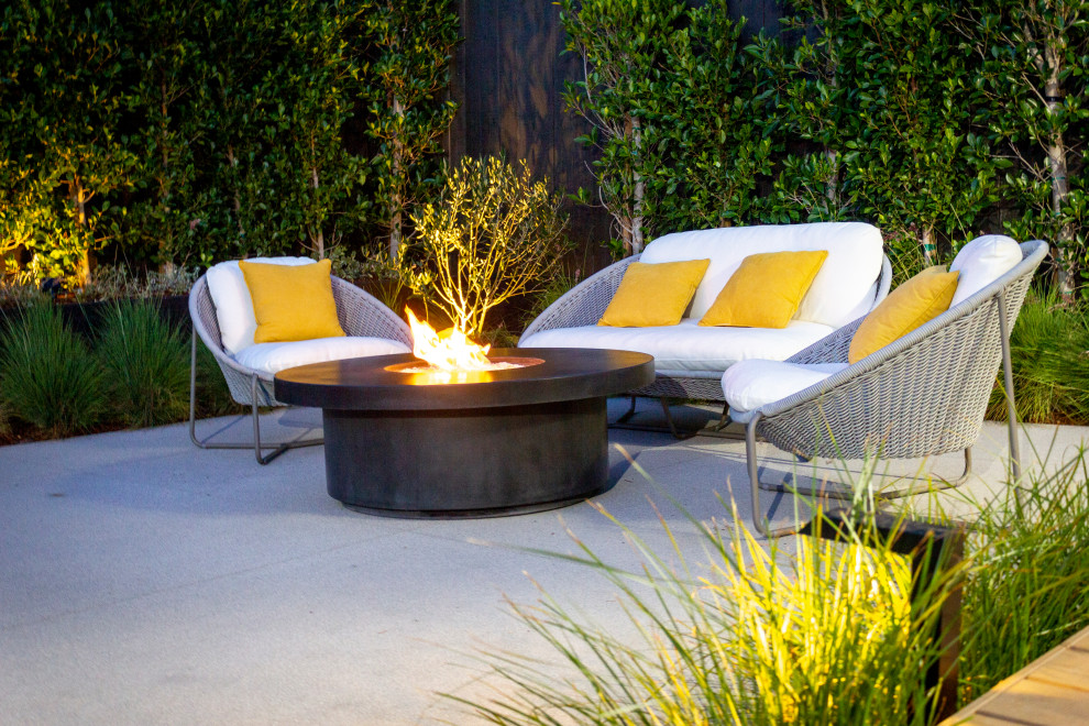 Design ideas for a mid-sized mid-century modern partial sun backyard landscaping in Los Angeles with decking for fall.