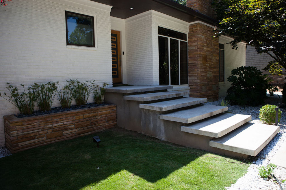 Immagine di un giardino xeriscape minimalista esposto a mezz'ombra di medie dimensioni e davanti casa in estate con un ingresso o sentiero e ghiaia