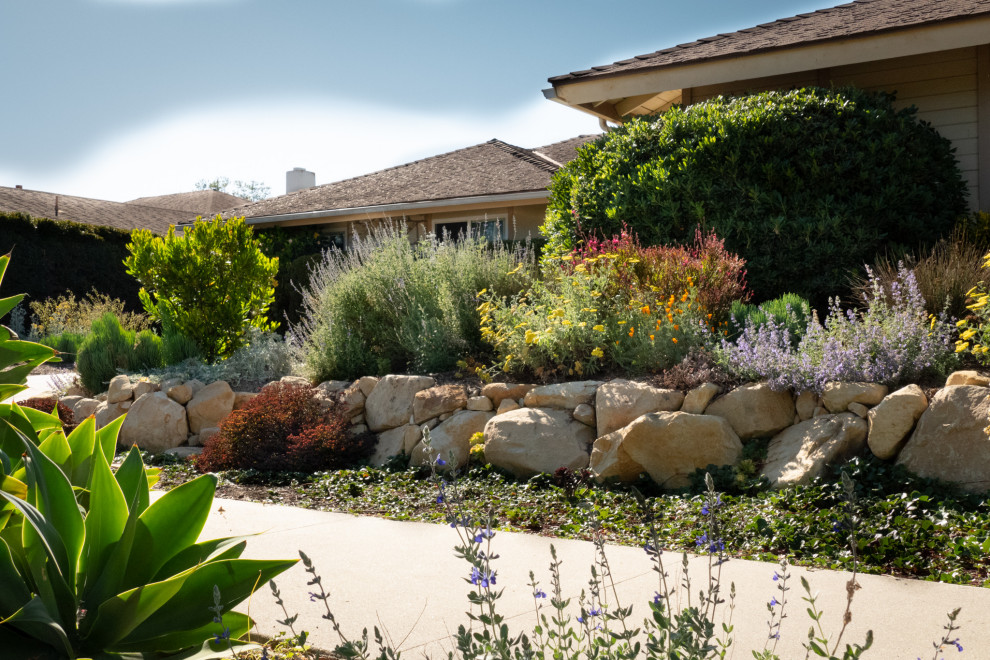 Photo of a medium sized eclectic front xeriscape full sun garden in Santa Barbara with a retaining wall and decorative stones.