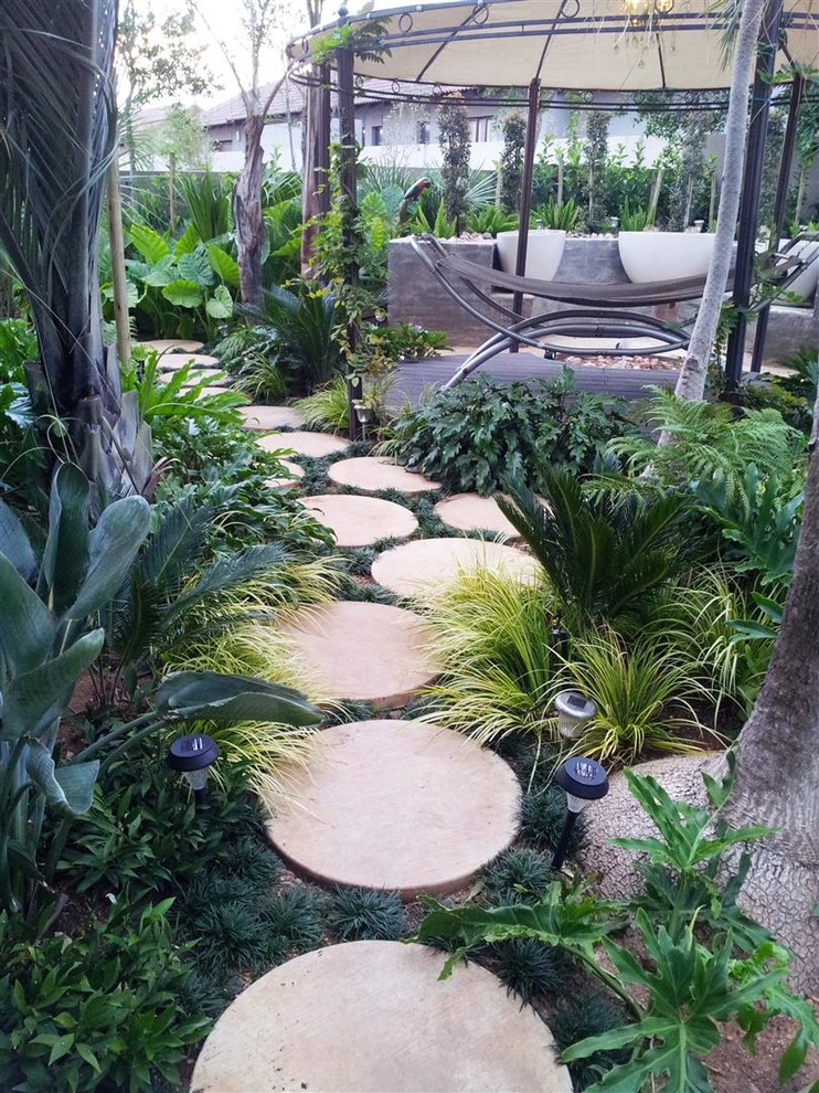 This is an example of a tropical shade backyard landscaping in Other.