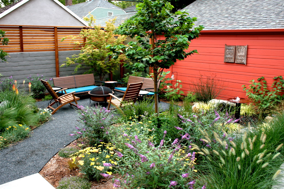 Photo of a contemporary back garden in Sacramento with a fire feature and gravel.