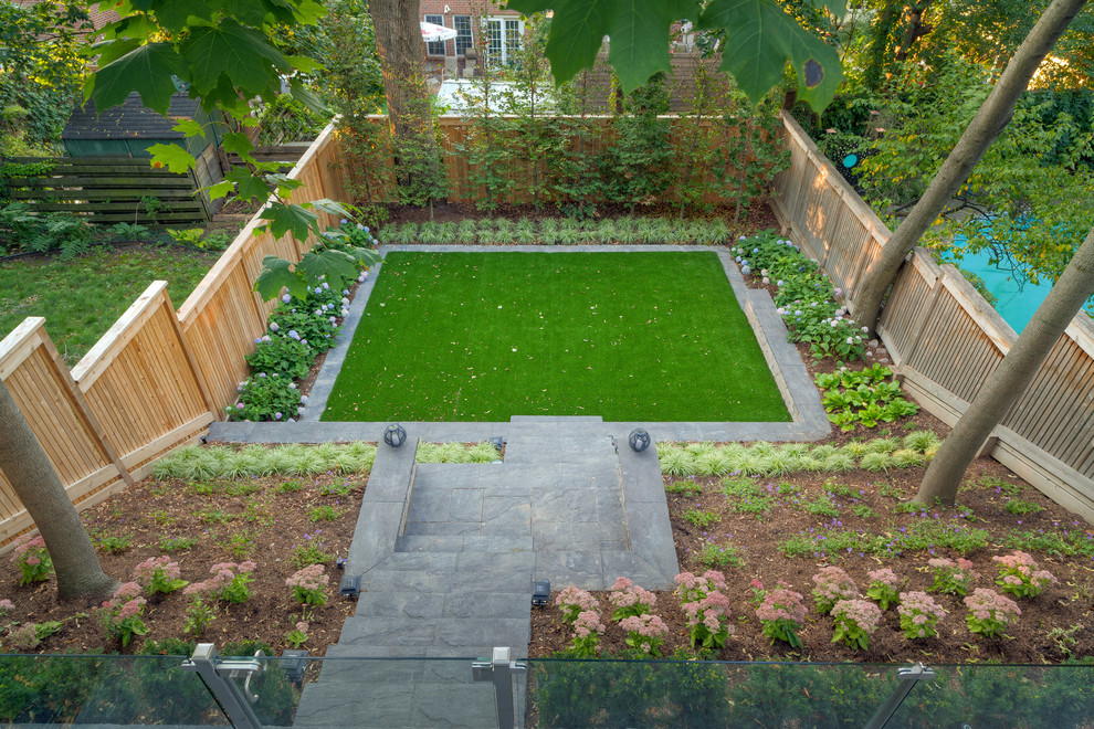 Ejemplo de jardín moderno de tamaño medio en verano en patio trasero con jardín francés, muro de contención, exposición total al sol y adoquines de hormigón