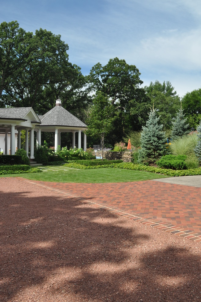 Design ideas for a traditional driveway garden in Chicago with brick paving.