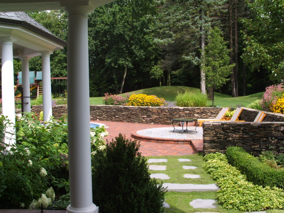 Foto di un giardino chic dietro casa con pavimentazioni in mattoni e scale