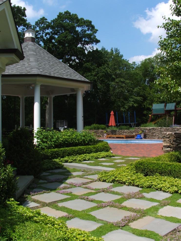 Immagine di un giardino chic dietro casa con pavimentazioni in pietra naturale e gazebo