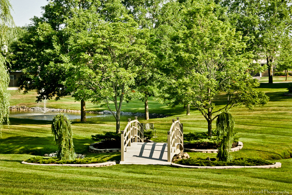 Idéer för en stor klassisk bakgård i delvis sol på våren, med en fontän och trädäck