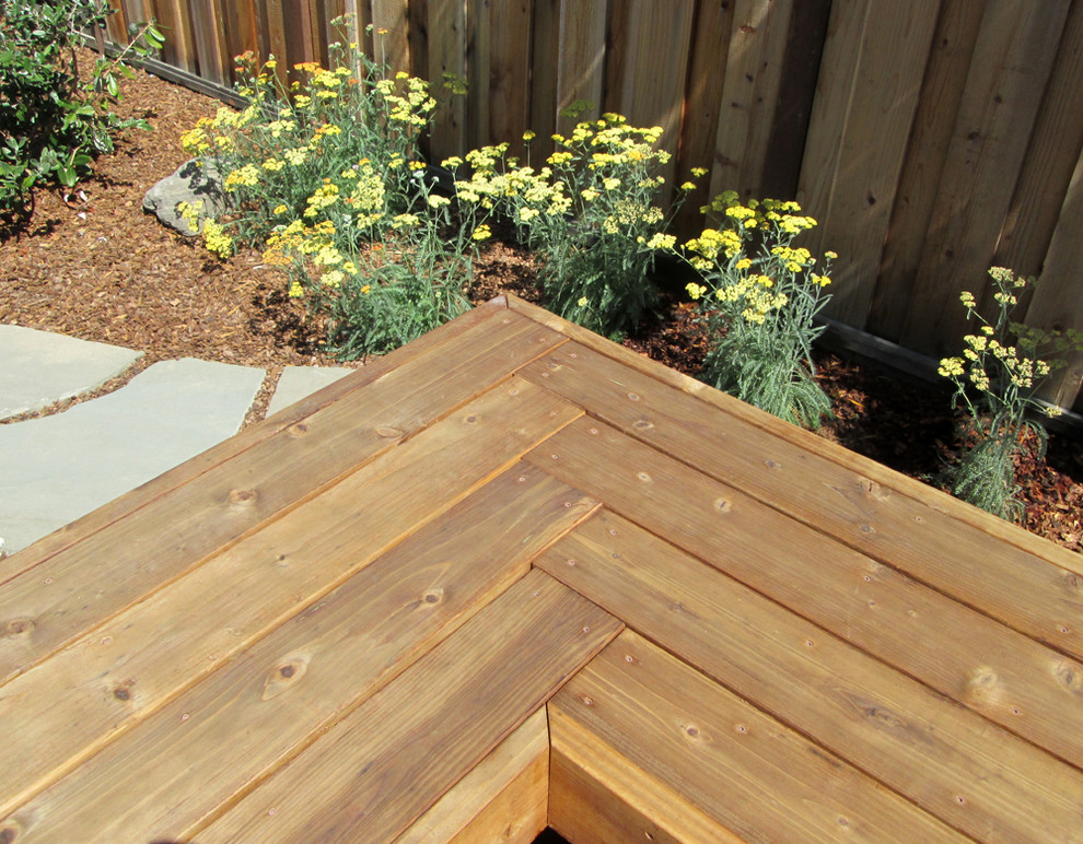 Cette photo montre un grand jardin arrière craftsman l'été avec une exposition ensoleillée et une terrasse en bois.