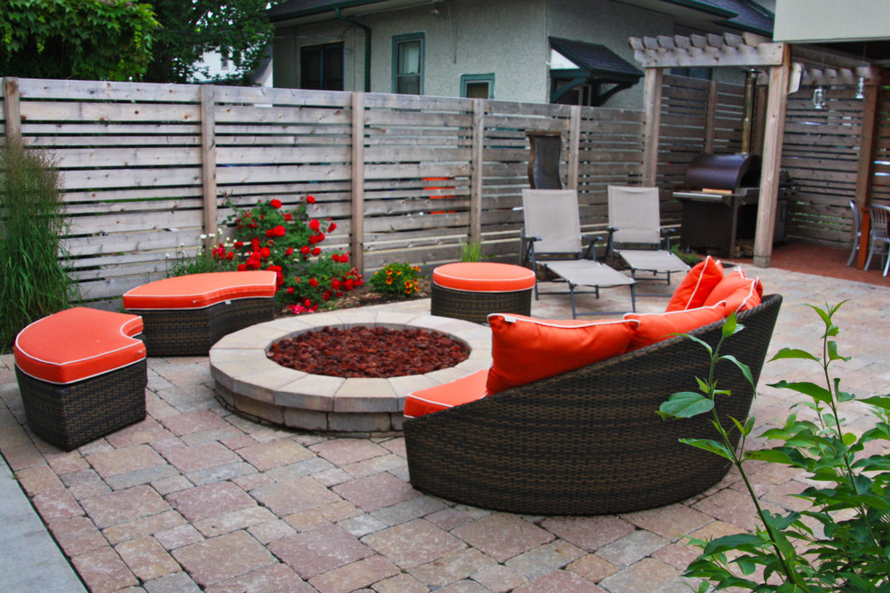 Example of a small trendy backyard concrete paver patio design in Milwaukee with a fire pit