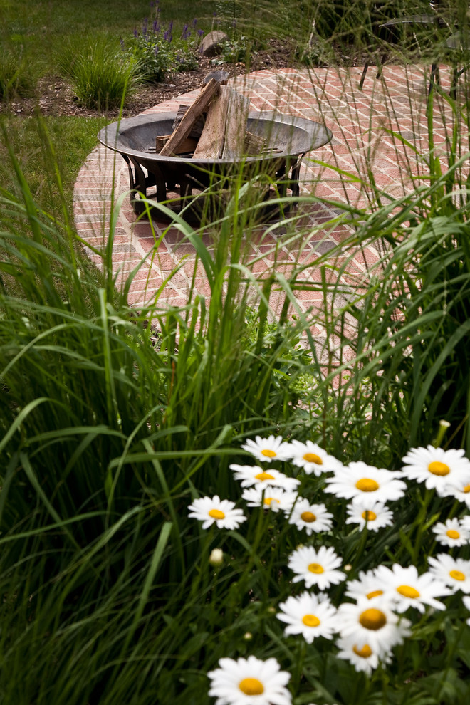 Inspiration pour un jardin arrière bohème de taille moyenne et l'été avec un foyer extérieur, une exposition ensoleillée et des pavés en brique.