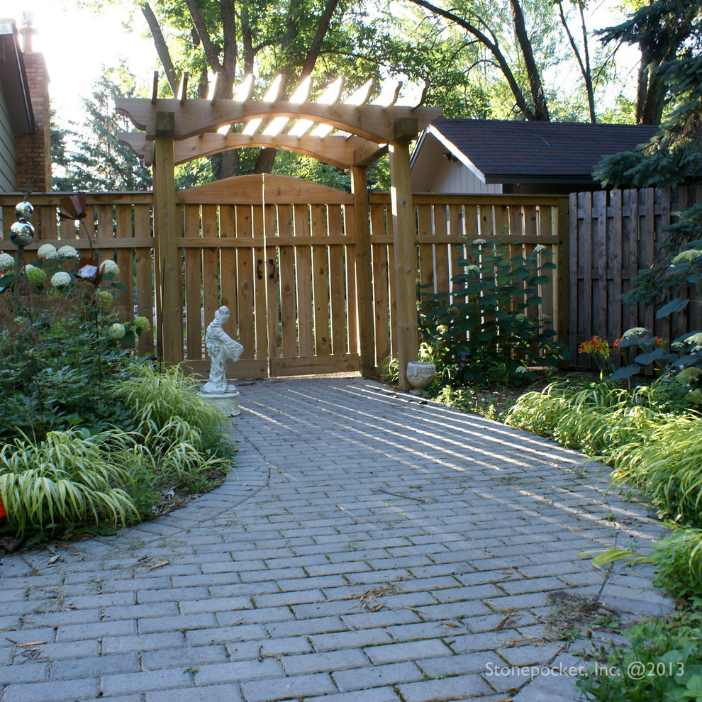 Foto de jardín tradicional de tamaño medio en verano en patio lateral con exposición parcial al sol y adoquines de hormigón