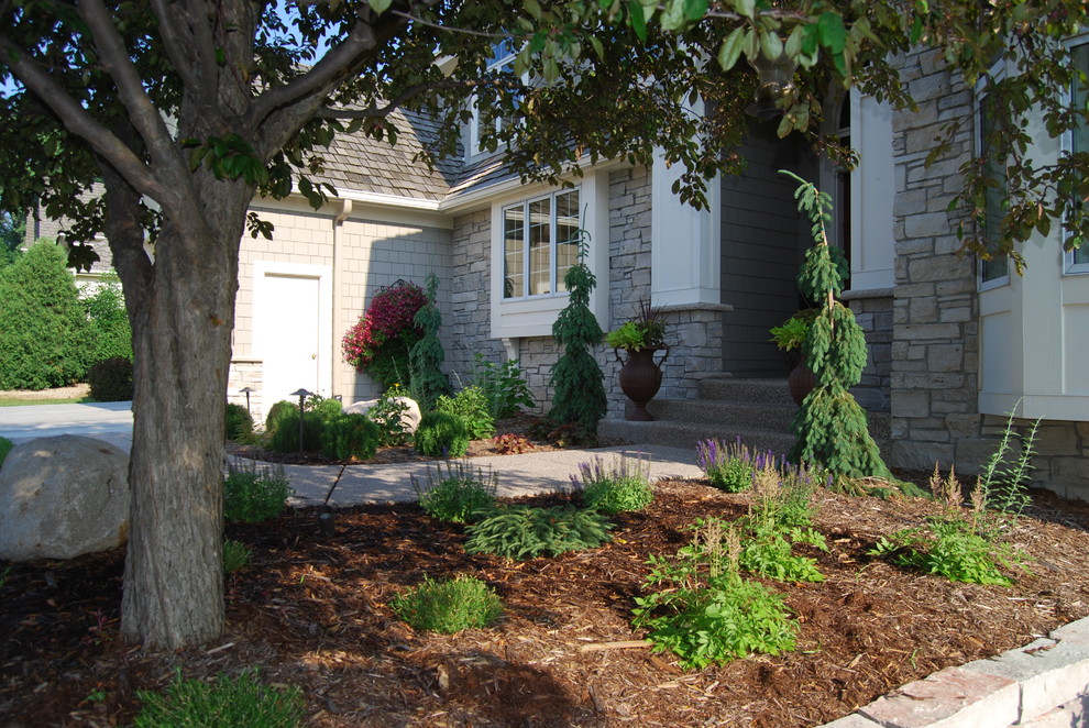 Medium sized traditional front formal partial sun garden in Minneapolis with a retaining wall and concrete paving.