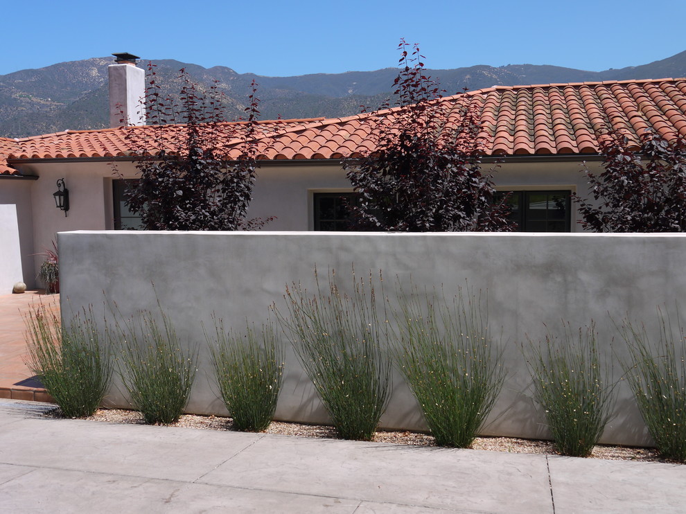 This is an example of a small contemporary drought-tolerant and full sun front yard concrete paver retaining wall landscape in Santa Barbara for summer.