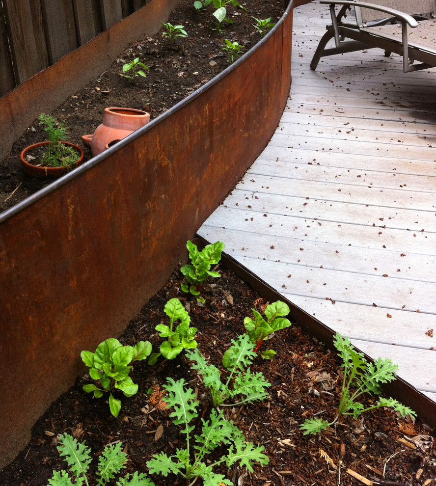 Cette photo montre un petit jardin potager arrière tendance avec une exposition partiellement ombragée et une terrasse en bois.
