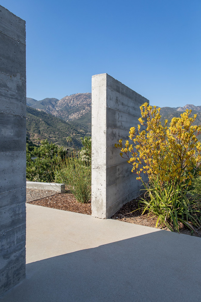 Große Moderne Gartenmauer hinter dem Haus mit direkter Sonneneinstrahlung und Betonboden in Santa Barbara