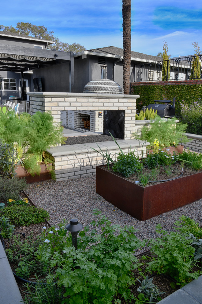 Moderner Kiesgarten hinter dem Haus mit Hochbeet und direkter Sonneneinstrahlung in San Diego