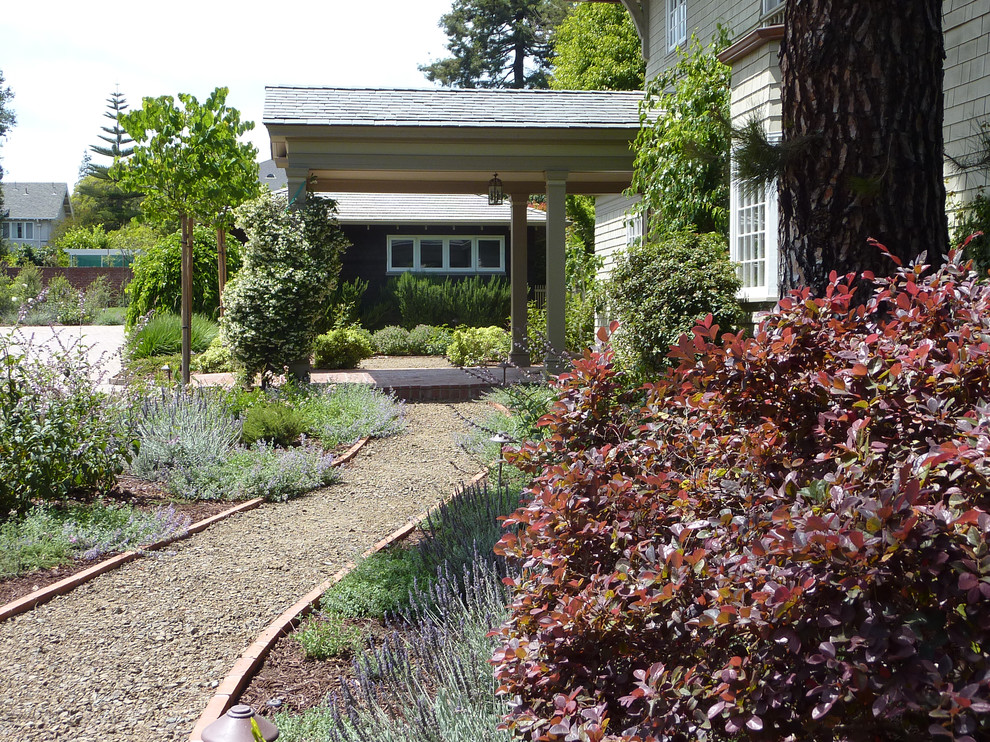Foto di un grande giardino formale tradizionale esposto in pieno sole davanti casa in estate con un ingresso o sentiero e ghiaia