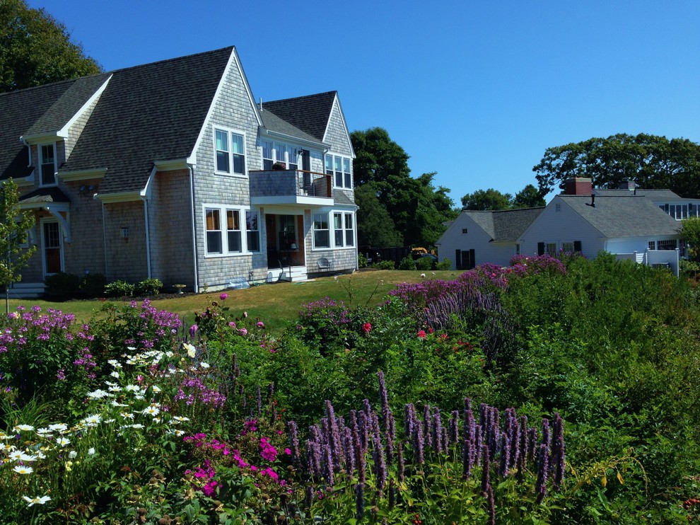 Foto di un grande giardino stile marino esposto in pieno sole dietro casa in estate