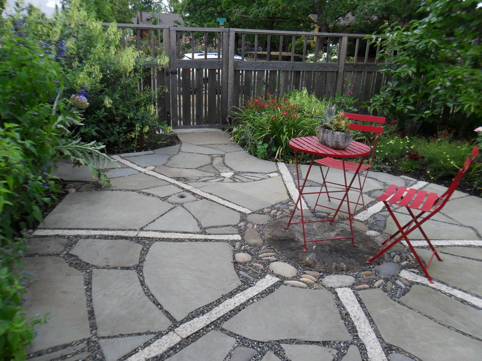 Imagen de jardín bohemio pequeño en verano en patio trasero con exposición total al sol y adoquines de piedra natural
