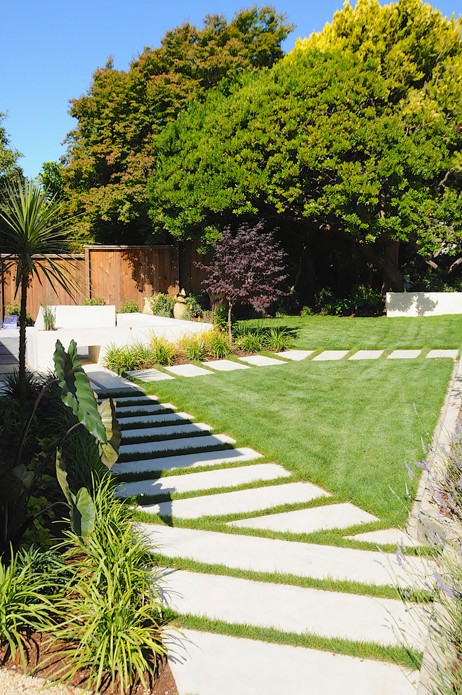 Пример оригинального дизайна: участок и сад на заднем дворе в стиле модернизм с мощением тротуарной плиткой