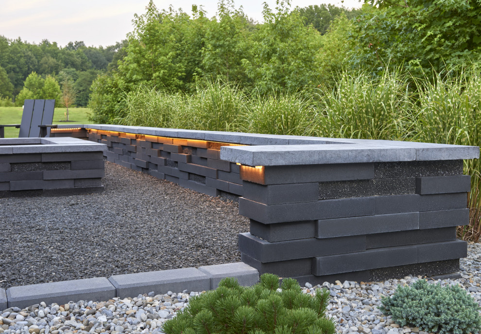 Inspiration för moderna trädgårdar, med en öppen spis och marksten i betong