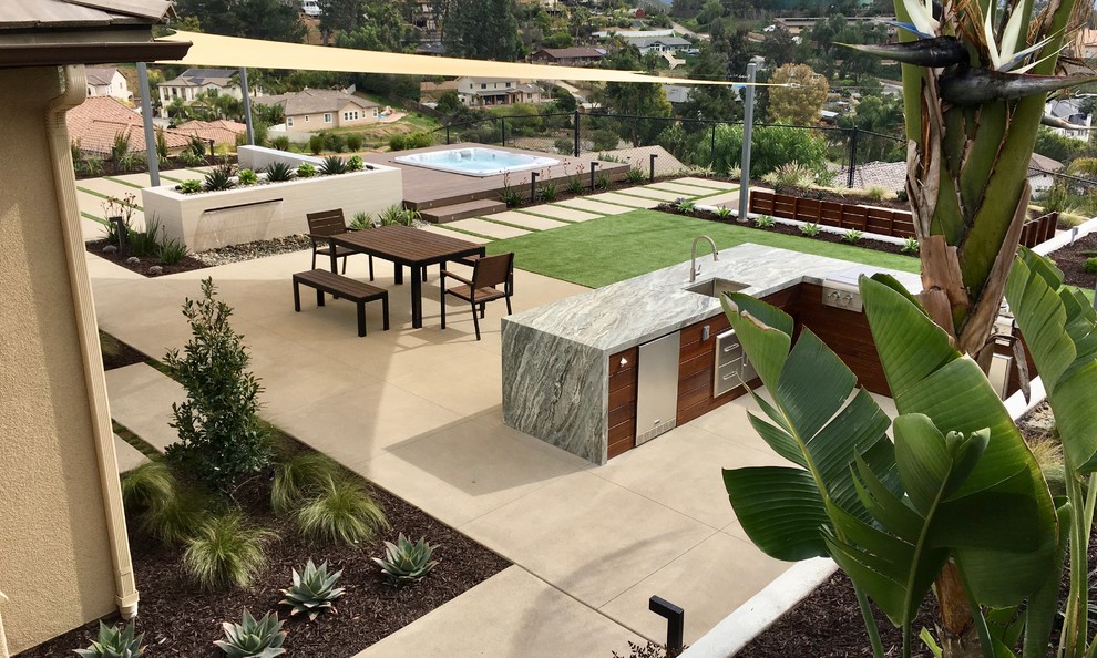 Ispirazione per un giardino xeriscape minimalista esposto in pieno sole di medie dimensioni e dietro casa con fontane e pavimentazioni in cemento