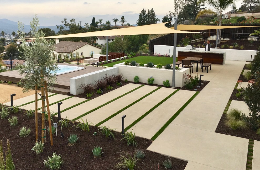 Mittelgroße Moderne Gartenmauer hinter dem Haus mit direkter Sonneneinstrahlung und Dielen in San Diego