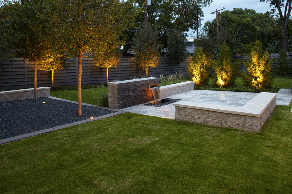 Immagine di un giardino minimalista esposto in pieno sole di medie dimensioni e dietro casa con fontane e pavimentazioni in pietra naturale