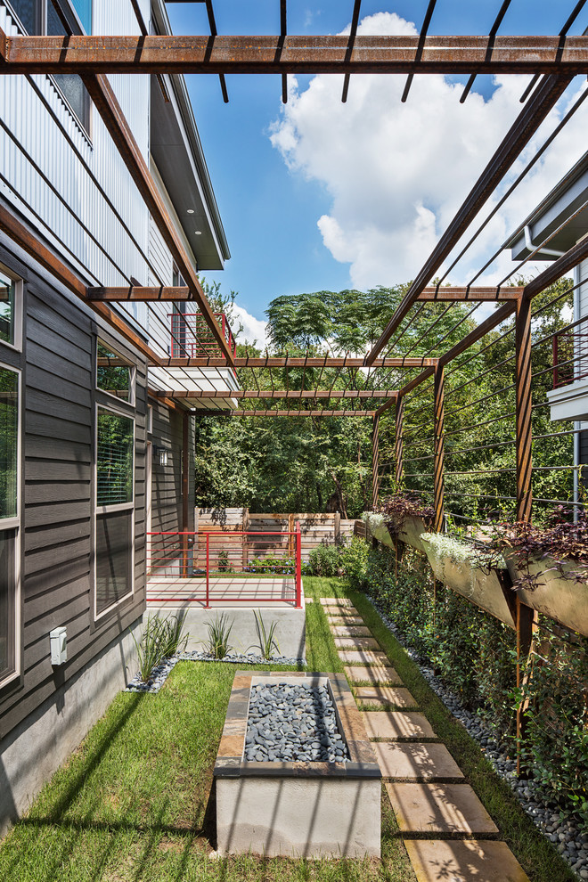Esempio di un piccolo giardino minimalista esposto a mezz'ombra dietro casa in estate con un giardino in vaso e pavimentazioni in pietra naturale