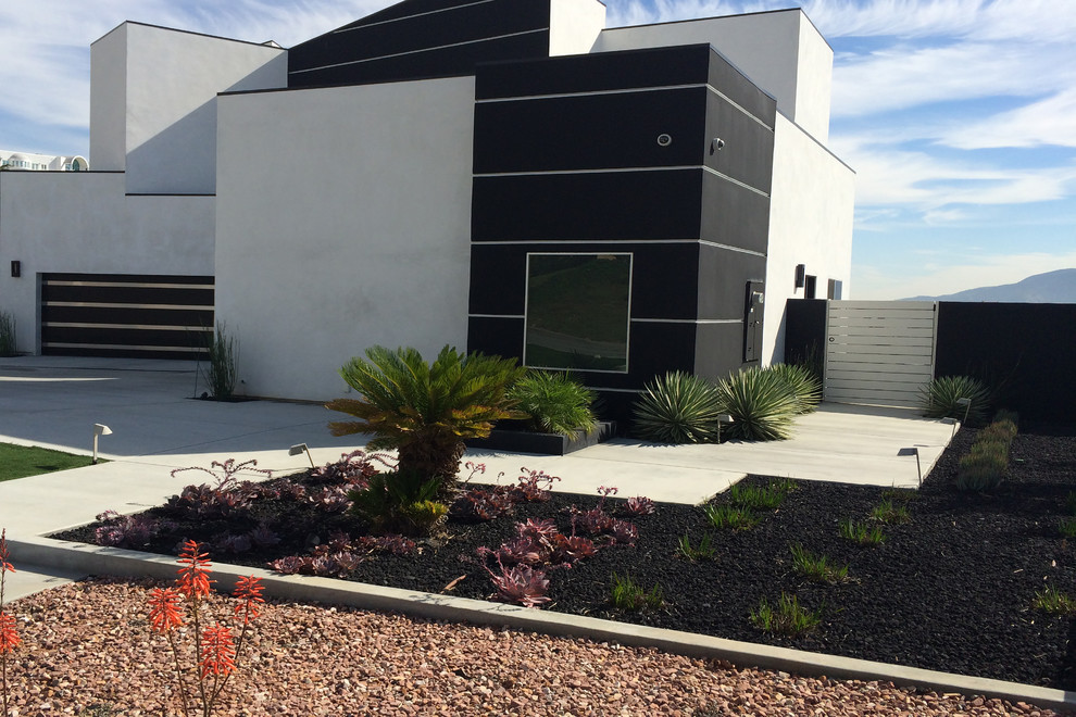 Medium sized contemporary side xeriscape full sun garden in Orange County with a garden path and concrete paving.