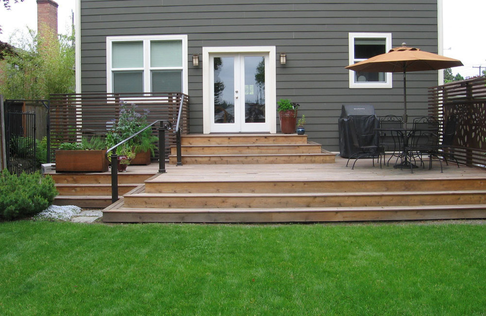 Photo of a large classic front full sun garden in Seattle with natural stone paving.