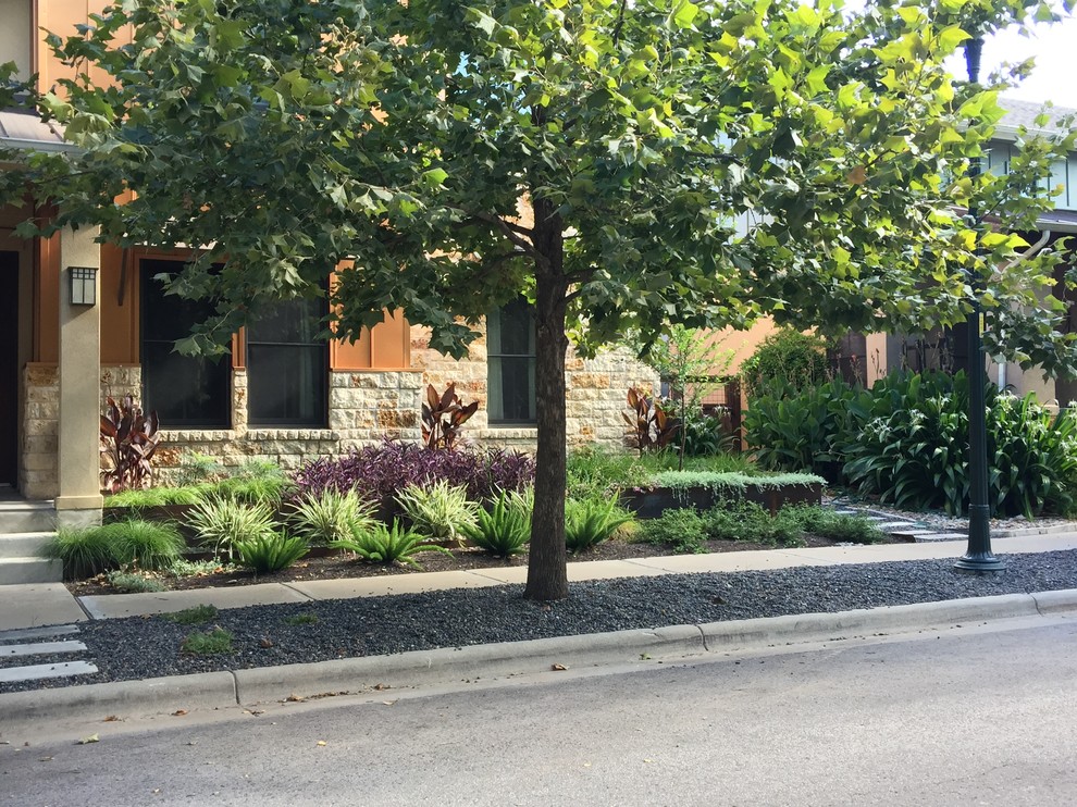 Esempio di un piccolo giardino moderno esposto a mezz'ombra davanti casa con un muro di contenimento e ghiaia