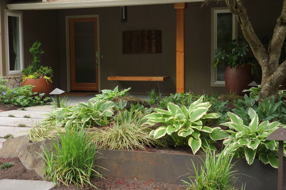 Imagen de acceso privado moderno de tamaño medio en primavera en patio delantero con exposición reducida al sol y adoquines de hormigón