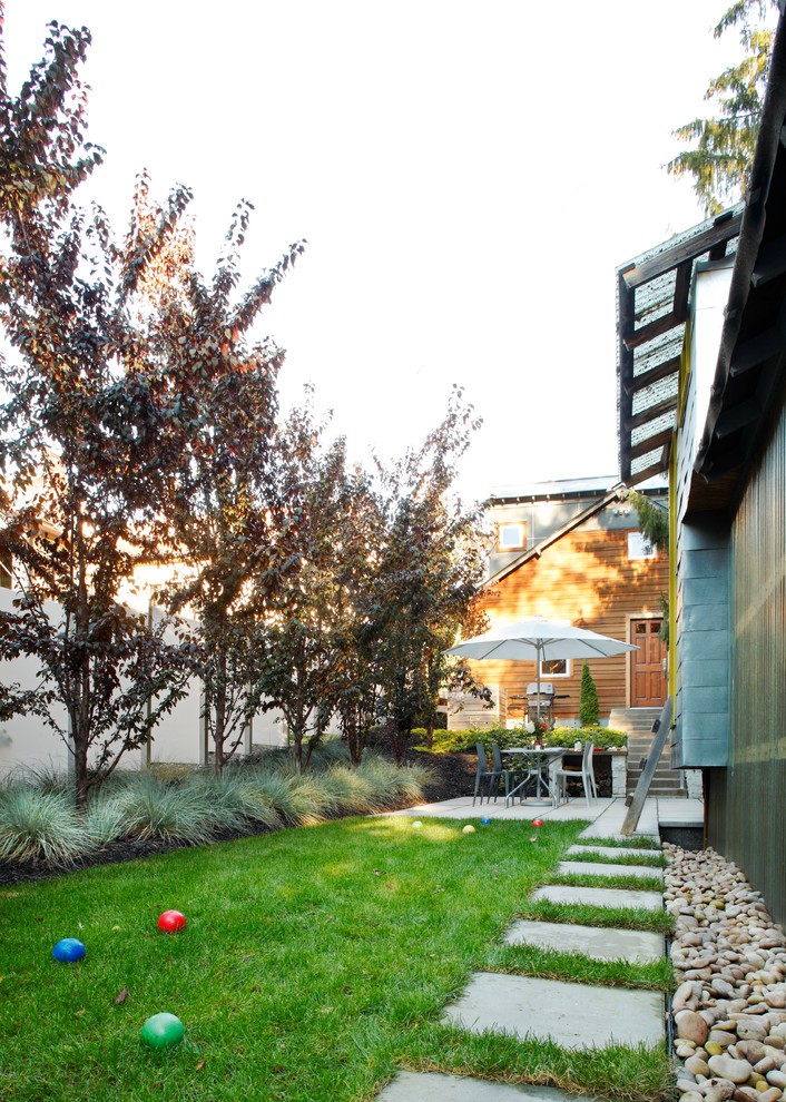Diseño de jardín contemporáneo en patio trasero con jardín francés, exposición parcial al sol y adoquines de hormigón