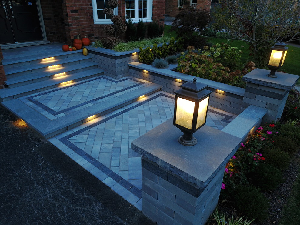 This is an example of a mid-sized modern full sun front yard concrete paver landscaping in Other.